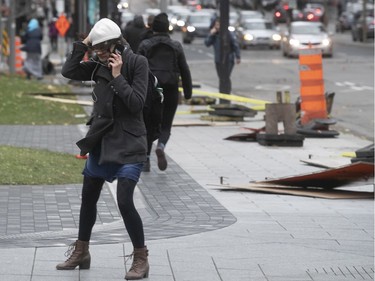 Montrealers brave high winds as they walk along René-Levesque and de la Cathedrale on Friday November 1, 2019.