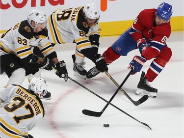 Montreal Canadiens defenseman Ben Chiarot (8) pushes puck away from Boston Bruins' David Pastrnak (88), Brad Marchand (63) and Patrice Bergeron (37), during first period NHL action in Montreal on Tuesday November 5, 2019.