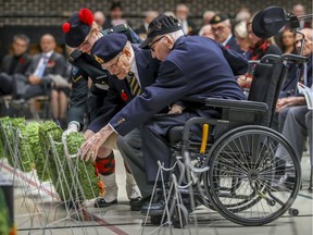 Private Florence Regimbald-Roy of the Black Watch Regiment helps veterans Benoit Duval and Maurice Gingerysty, right, place a wreath during a Remembrance Day ceremony at Ste. Anne's Hospital in Ste-Anne-de-Bellevue on Nov. 3 .