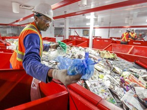 Jean Petithomme sorts recyclable materials at the new recycling plant in Lachine Nov. 12, 2019.