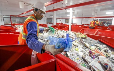 Jean Petithomme sorts recyclable materials at the new recycling plant in Lachine Nov. 12, 2019.