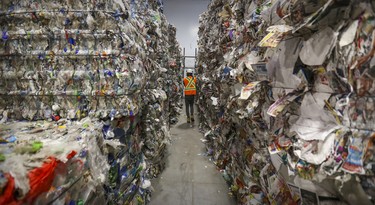 A cameraman walks between bales of recycled materials at Montreal's new recycling plant in Lachine Nov. 12, 2019.