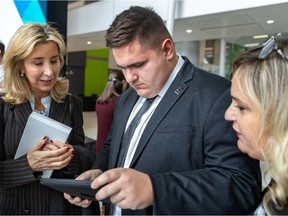 Marie-Joseé Coutu checks out Benjamin Talbot's web site with his mother, Maude Roy, right, looking on at Sainte-Justine Hospital on Tuesday, Nov. 12, 2019.