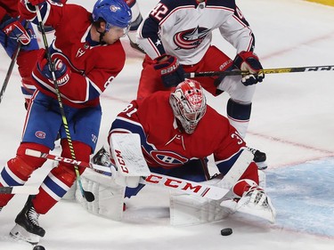 Montreal Canadiens goaltender Carey Price jumps on puck while Columbus Blue Jackets' Alexandre Texier (42) comes in from behind and Ben Chiarot (8) comes in to help his teammate, during third period NHL action in Montreal on Tuesday November 12, 2019.