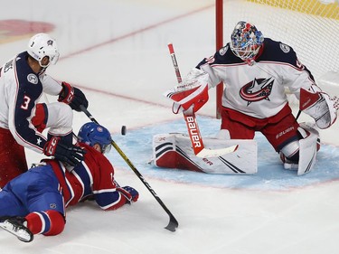 Montreal Canadiens Max Domi (13) slides towards Columbus Blue Jackets goaltender Elvis Merzlikins after being brought down by Columbus Blue Jackets' Seth Jones (3) during second period NHL action in Montreal on Tuesday November 12, 2019.