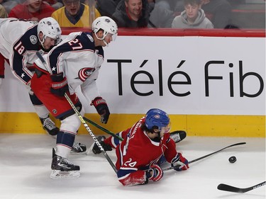 Montreal Canadiens Phillip Danault (24) moves puck away from Columbus Blue Jackets Ryan Murray (27) and Pierre-Luc Dubois (18) during first period NHL action in Montreal on Tuesday November 12, 2019.
