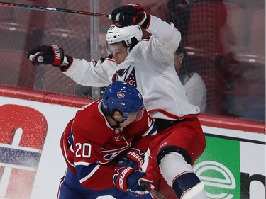 Montreal Canadiens Cale Fleury (20) gives a good hit on Columbus Blue Jackets Josh Anderson (77) during first period NHL action in Montreal on Tuesday November 12, 2019.