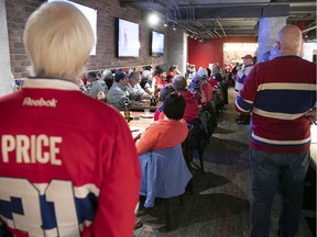 HI/O Summit organizer Ian Cobb (in white Canadiens sweater with red cap) addresses fans during lunch at La Cage Brasserie Sportive at the Bell Centre on Saturday, Nov. 16, 2019.