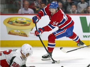 Montreal Canadiens' Charles Hudon shoots the puck past a sliding Ottawa Senators' Nikita Zaitzev during first period in Montreal on Nov. 20, 2019.