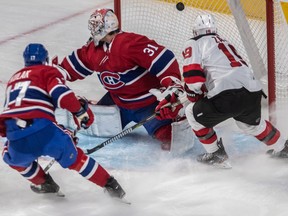 Canadiens goaltender Carey Price can't stop Devils centre Travis Zajac from scoring as defenceman Brett Kulak trails helplessly on the play during the first period Thursday night at the Bell Centre.