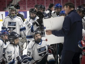 Lester B. Pearson Kings and Lac St. Louis Lions bantam hockey players listen to former Montreal Canadien Gaston Gingras at the Bell Centre on Nov. 29, 2019.