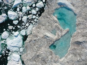 Melting ice forms a lake on free-floating ice jammed into the Ilulissat Icefjord in July 2019 near Ilulissat, Greenland.