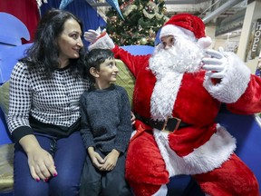 Sud-Ouest borough mayor Benoit Dorais plays Santa as Elham Nemati and her son, Padra, celebrate their first Christmas in Canada at Welcome Hall Mission's Noel pour tous gift giveaway in Montreal on Saturday, Nov. 30, 2019. Nemati and her son immigrated from Iran in the last year.