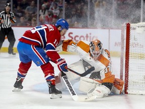 Canadiens' Brendan Gallagher kicks up ice spray as he puts on the brakes in front of Philadelphia Flyers goalie Brian Elliott in Montreal on Saturday, Nov. 30, 2019.