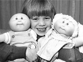 Karen Baguley, 7, holds two Cabbage Patch Kids, the must-have doll for Christmas 1983, on Nov. 24, 1983. The photo was published in the Montreal Gazette the following day.