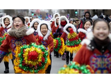 Young dancers from Montreal's Chinese community laugh as they run to get in to place during the annual Santa Claus parade in Montreal on Saturday, Nov. 23, 2019.