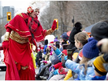 A performer on stilts interacts with the crowd during the annual Santa Claus parade in Montreal on Saturday, Nov. 23, 2019.