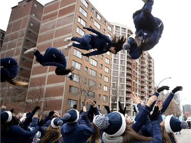 Cheerleaders are tossed in the air during the annual Santa Claus parade in Montreal on Saturday, Nov. 23, 2019.