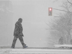 A man crosses St Laurent near Notre Dame while the snows falls around him on Thursday December 29, 2016.