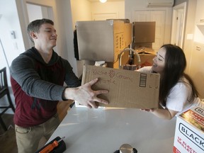 Josh Faier hands over boxes of kitchen accessories to Ally Brumer as the couple move into their Ville-Émard condo.