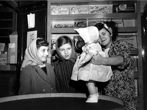 A well-dressed postwar doll is shown to two Montreal misses by May Duhamel, salesgirl. It is only one of the Christmas prizes that have returned to city toytowns after a long absence. Store managers say that prices are higher but quality is better.   Nov. 15, 1947.