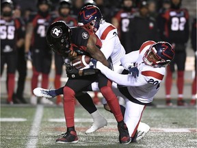 Ottawa Redblacks quarterback Dominique Davis (4) gets sacked by Montreal Alouettes defensive back Patrick Levels (3) and linebacker Boseko Lokombo (20) during first half CFL football action in Ottawa on Friday, Nov. 1, 2019.