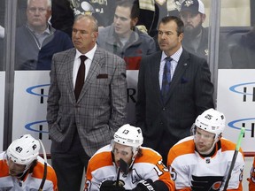 Philadelphia Flyers head coach Alain Vigneault, right, and assistant Michel Therrien stand behind their bench during the first period against the Penguins in Pittsburgh on Oct. 29, 2019.