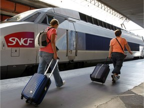 People walk on a platform to take a TGV (High Speed Train) at the Gare St-Charles station in Marseille, southern France , Thursday, June 12, 2014.