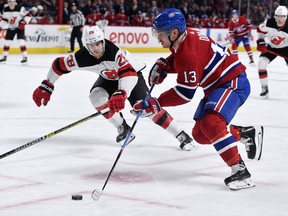 Canadiens' Max Domi  plays the puck and New Jersey Devils defenceman Damon Stevenson defends at the Bell Centre on Saturday, Nov. 16, 2019.