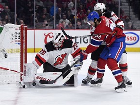 New Jersey Devils goalie Mackenzie Blackwood  stops Canadiens' Phillip Danault with the help of teammate P.K. Subban (76) at the Bell Centre in Montreal on Saturday, Nov. 16, 2019.