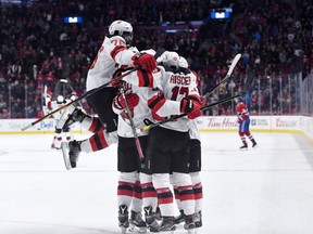 New Jersey players celebrate with Kyle Palmieri after he scored in overtime to give the Devils a 4-3 win over the Canadiens in NHL action at the Bell Centre in Montreal on Nov. 16, 2019.