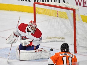 Canadiens goaltender Carey Price allows the winning goal to get by him in overtime as Travis Konecny looks on.