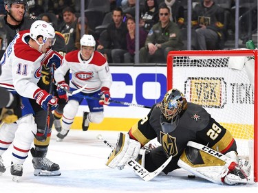 Montreal Canadiens' Brendan Gallagher deflects the puck between the legs of Vegas Golden Knights goaltender Marc-Andre Fleury (29) to score a third period goal at T-Mobile Arena.