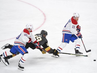 Vegas Golden Knights right wing Alex Tuch (89) is tripped up by Montreal Canadiens left wing Tomas Tatar (90) as he tips the puck away from  Montreal Canadiens right wing Brendan Gallagher (11) during the first period at T-Mobile Arena.