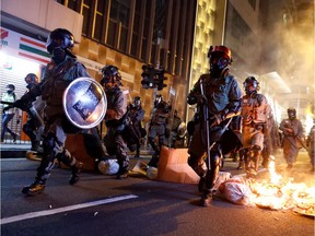Police pass a burning barricade to break up thousands of anti-government protesters during a march billed as a global "emergency call" for autonomy, in Hong Kong on Nov. 2.
