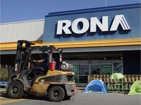 A man drives a forklift in front of a Rona home improvement store in St. Eustache, Que., just outside Montreal, on Thursday, July 16, 2015. The Lowe's home improvement chain is buying Quebec-based Rona Inc. in a deal valued at $3.2 billion.