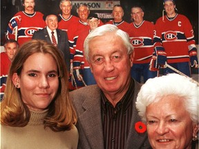 Jean Béliveau with his granddaughter Magalie Roy, 13, and wife Elise on Nov. 11, 1999. Behind are photos of past Canadiens' greats.