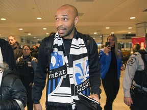 New Montreal Impact coach Thierry Henry greets fans as he arrives at Trudeau airport in Montreal Thursday night.