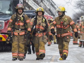 MONTREAL, QUE.: JANUARY 26, 2019 -- Firefighters walk on Wellington Ave. In the Verdun area of Montreal, on Saturday, January 26, 2019.  Firefighters had 2 separate fires to battle: one on 6th Ave. and another a few blocks away on Wellington Ave. (John Kenney / MONTREAL GAZETTE) ORG XMIT: 62052