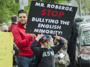 Adam Ross Noble holds up a sign and blows a whistle as he and other students, parents and teachers formed a chain around General Vanier Elementary school in St-Léonard on June 5, 2019, "to save our school, raise awareness, solidarity, and raise school spirit." The school is one of three east end schools that may be taken away from the English Montreal School Board to resolve an overcrowding problem at a French-language board.