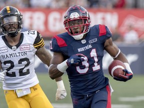 Alouettes' William Stanback runs away from Tiger-Cats' Justin Tuggle during a game at Molson Stadium. The tailback gained 1,048 yards on 170 carries while scoring five touchdowns last season. His average of 6.2 yards led the CFL.