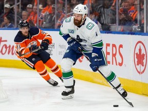 Canucks' Jordie Benn moves the puck while being pursued pursued by Oilers' Gaetan Haas. The former Canadien signed a two-year deal worth US$4 million this past off-season to play in Vancouver.
