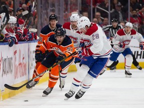 Patrick Russell of the Edmonton Oilers moves the puck past Canadiens' Mike Reilly  at Rogers Place on Saturday, Dec. 21, 2019, in Edmonton.