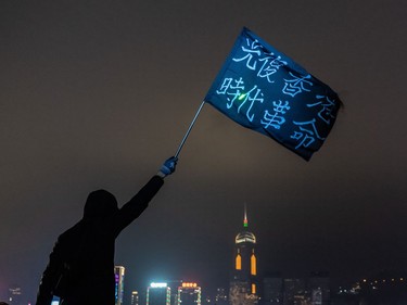 A pro-democracy supporter waves flag ahead of a countdown party in Tsim Sha Tsui district on New Year's eve on December 31, 2019 in Hong Kong, China. Anti-government protesters in Hong Kong continue their demands for an independent inquiry into police brutality, the retraction of the word "riot" to describe the rallies, and genuine universal suffrage.