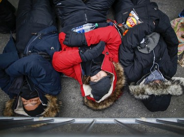 People take a nap as they wait to celebrate New Years eve in Times Square on December 31, 2019 in New York City. Because of the mild weather, a larger than usual crowd of people visiting from all over the world is expected to watch the ball drop.
