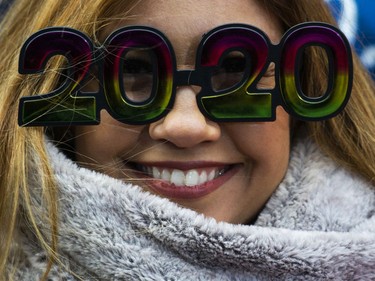 A woman wears glasses as she waits to celebrate New Years Eve in Times Square on December 31, 2019 in New York City. Because of the mild weather, a larger than usual crowd of people visiting from all over the world is expected to watch the ball drop.