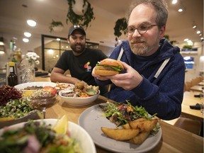 Ezra Soiferman, a Montreal filmmaker and hemp enthusiast, prepares to dig into a hemp-based burger as Hello 123 co-owner Eric Blake looks on.