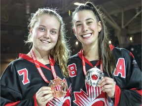 Lydia Duncan, left, shows off her gold medal along with teammate Julie Vandal after their Canadian ringette team beat Finland to win the junior title at the 2019 World Ringette Championships in Burnaby, B.C., on Nov. 30.