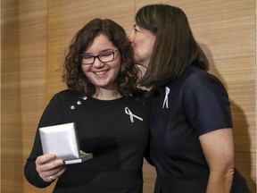 Nathalie Provost, a survivor of the Polytechnique massacre, kisses Édith Ducharme, this year's winner of the $30,000 Order of the White Rose bursary.