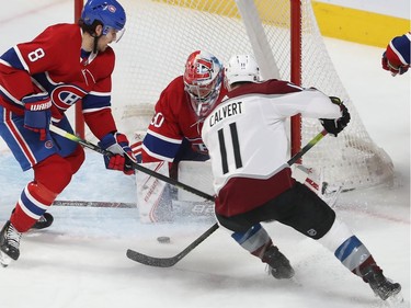 Colorado's Matt Calvert (11) gets in close on Montreal Canadiens goaltender Cayden Primeau with Ben Chiarot (8) coming in on play, during first period NHL action in Montreal on Thursday December 05, 2019.